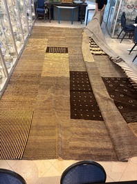 A very large Persian hand-knotted woollen carpet with a geometric patchwork design, 20th C.