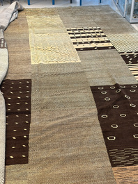 A very large Persian hand-knotted woollen carpet with a geometric patchwork design, 20th C.