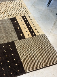 A large Persian hand-knotted woollen carpet with a geometric patchwork design, 20th C.
