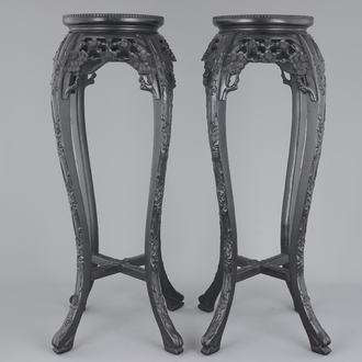 A tall pair of Chinese carved stands with marble top, 19th C.