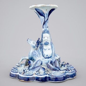 A blue and white Dutch Delft candlestick with a deer and a buddhist, 18th C.