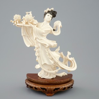 Een Chinese ivoren figuur van een danseres met bloemen op sokkel, 1e helft 20e eeuw