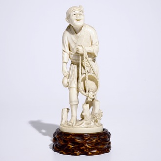 Een Japanse ivoren okimono van een visser op houten sokkel, Meiji, 19e eeuw, gesigneerd