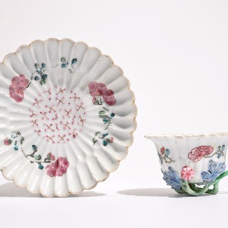 Een Chinese famille rose lotusvormige kop en schotel met reliëfdecor, Yongzheng