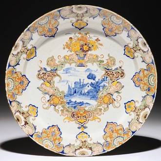 Een polychrome Delfts aardewerken schotel met landschapsmedaillon, 18e eeuw
