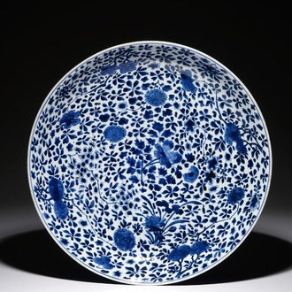 Een grote Chinese blauwwitte schotel met floraal decor en poederblauwe onderkant, Chenghua merk, Kangxi