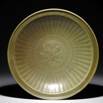 Een Chinese Longquan celadon schotel met floraal onderglazuur decor , Ming