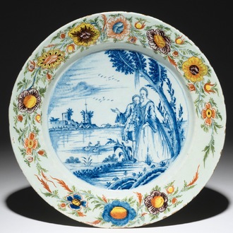 Een polychrome Delftse schotel in gemengde techniek met een galante scène, 18e eeuw