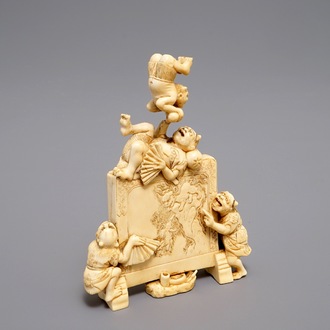 Een Japanse ivoren okimono met oni bij een scherm, gesigneerd, Meiji, 19e eeuw
