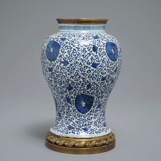 Een Chinese blauwwitte vaas met pioenslingers met montuur in verguld brons, Kangxi
