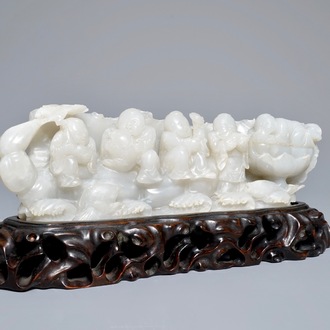 Een Chinese witte jade groep met jongens op een vlot op fijne houten sokkel, Qing