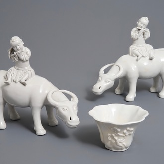 Deux modèles de joueurs de flute sur buffles et une tasse à vin en porcelaine blanc de Chine, 18/19ème