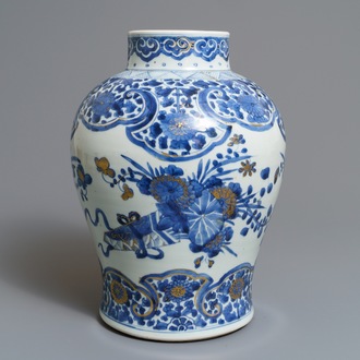 Een Chinese blauwwitte en vergulde vaas met floraal decor, Kangxi