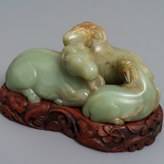 Een Chinese celadon en roestkleurige jade 'drie rammen' groep op fraaie houten voet, 19e eeuw