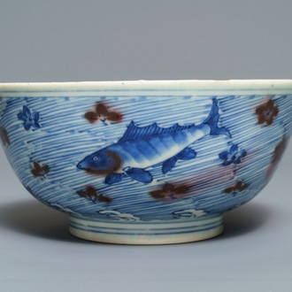 Een Chinese kom met blauw en onderglazuur rood decor van karpers en zeedieren, Xuande merk, Kangxi