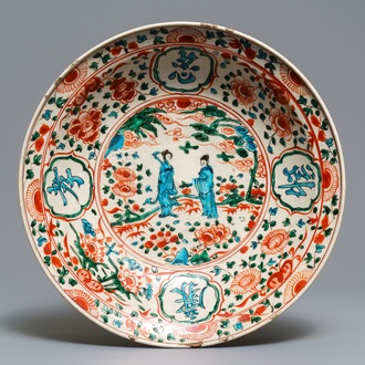 Een Chinese polychrome Swatow schotel met twee figuren in een landschap, Ming