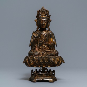 Een Chinese gelakt en verguld bronzen figuur van Guanyin op een lotustroon, Ming