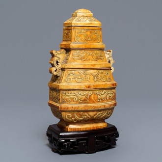 Een Chinese archaïsche ivoren dekselvaas op houten voet, ca. 1900