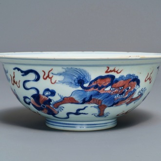 Een Chinese blauw-witte en onderglazuur rode kom met tempelleeuwen, Qianlong merk en periode