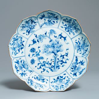 Een Chinese blauw-witte schotel in lotusvorm met floraal decor, Kangxi