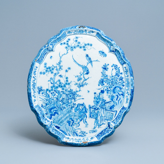 Een blauw-witte Delftse chinoiserie plaquette met figuren in een tuin, 18e eeuw