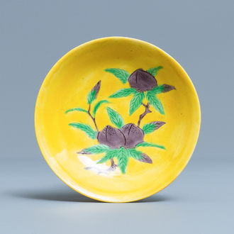 Een Chinees schoteltje met perziken in groen en aubergine op gele fondkleur, Kangxi