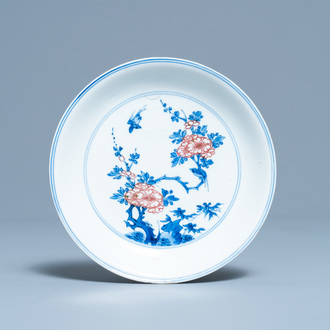 Een Chinees blauw-wit en koperrood bord met floraal decor, Kangxi