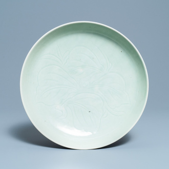 Een Chinese monochrome celadon schotel met onderglazuur floraal decor, 18/19e eeuw