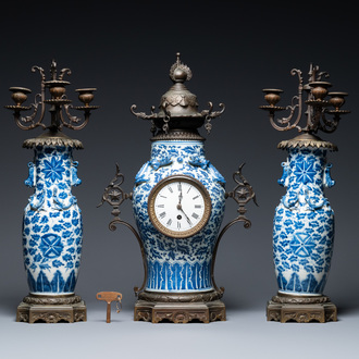 Een Chinese met brons gemonteerde driedelige klokgarnituur met blauw-witte vazen, 19e eeuw