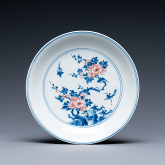 Een Chinees blauw-wit en koperrood bord met floraal decor, Kangxi