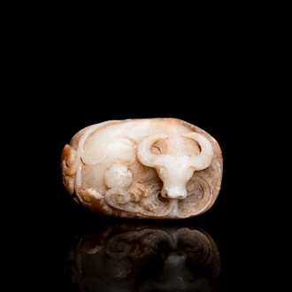 Een Chinese witte en roestkleurige jade hanger in de vorm van een buffel, 19e eeuw