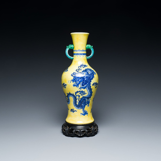 Een Chinese blauw-witte 'draken' vaas met gele fondkleur en groen-geglazuurde oren op een houten sokkel met jade, Jiaqing merk, 19/20e eeuw