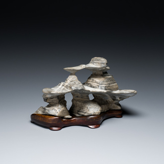 Een Chinese grijze lingbi steen van een geleerde op houten sokkel, 'gongshi', 19/20e eeuw