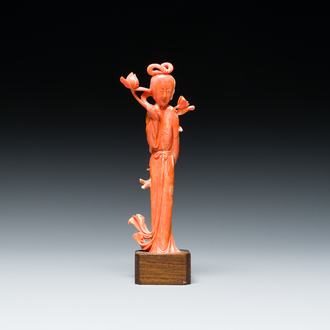 Een Chinese bloedkoralen sculptuur van een staande dame met een lotusbloem, 19/20e eeuw