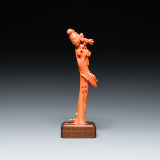 Een Chinese bloedkoralen sculptuur van een staande dame met een bloesemtak, 19/20e eeuw