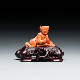 Een Chinese bloedkoralen sculptuur van een liggende jongen, 19/20e eeuw