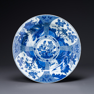 Een Chinese blauw-witte schotel met landschappen en florale panelen, Kangxi