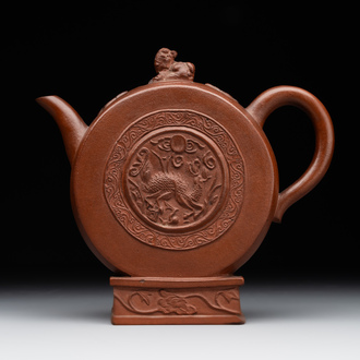 A Chinese circle-shaped Yixing stoneware 'kylin' teapot with relief design, Kangxi
