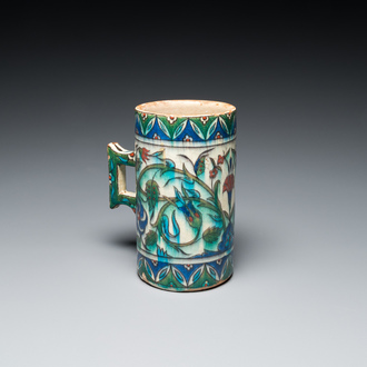 A polychrome Iznik-style mug with tulips and carnations, Kutahya, Turkey, 19th C.