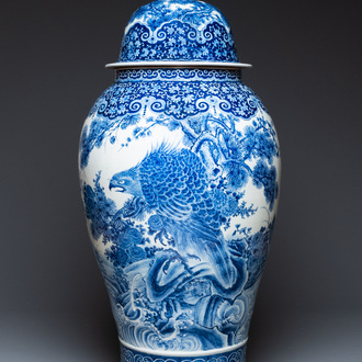 A massive Japanese blue and white Arita vase and cover with an eagle, a shishi and cub, 19th C.