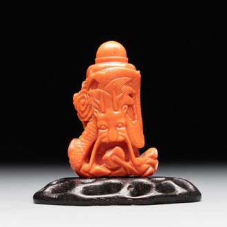 A Chinese carved red coral 'dragon' snuff bottle on wooden stand, 19/20th C.