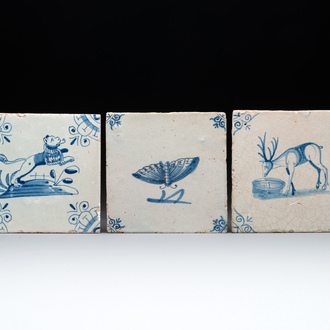 Three blue and white Dutch Delft tiles with a lion, a butterfly and a deer, 17th C.