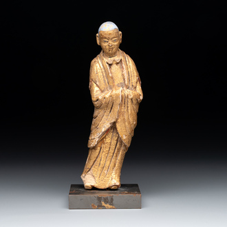 A Chinese gilt and polychromed stucco figure of a monk, Ming