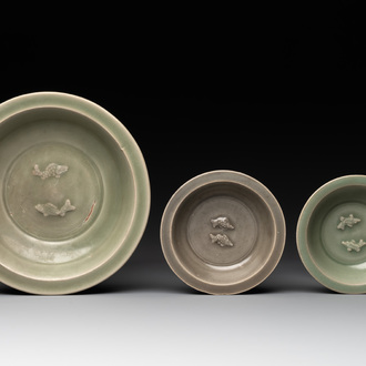A Chinese Longquan celadon 'twin fish' dish and two 'twin fish' saucers, Yuan/Ming