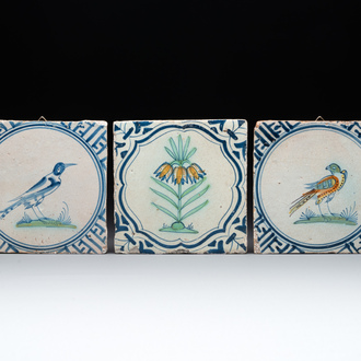 Three polychrome Dutch Delft tiles with birds and a flower, 17th C.