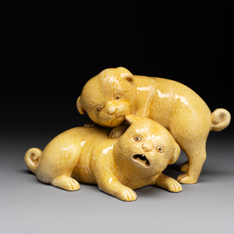A Japanese monochrome yellow-glazed 'two playing dogs' group, 19th C.