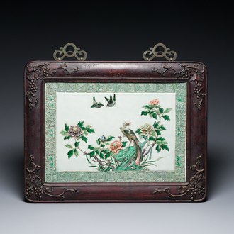 A Chinese famille verte relief-decorated 'peacock' plaque in a finely carved hongmu frame, 19th C.