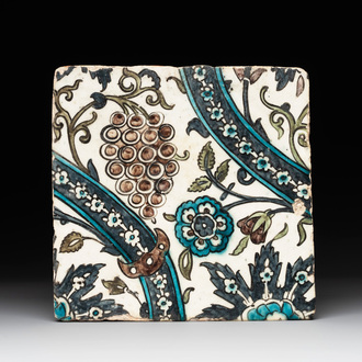 A Syrian Damascus Iznik-style tile with grape and flower scrolls, early 17th C.