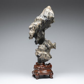A Chinese green Lingbi stone scholar's rock on wooden stand, 20th C.