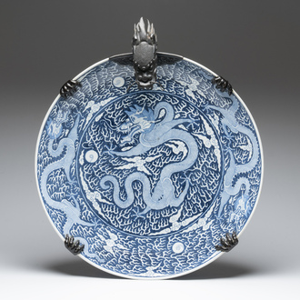 A massive Chinese blue and white reverse-decorated  'dragon' charger with bronze mounts, Chuxiu Gong Zhi mark, Guangxu